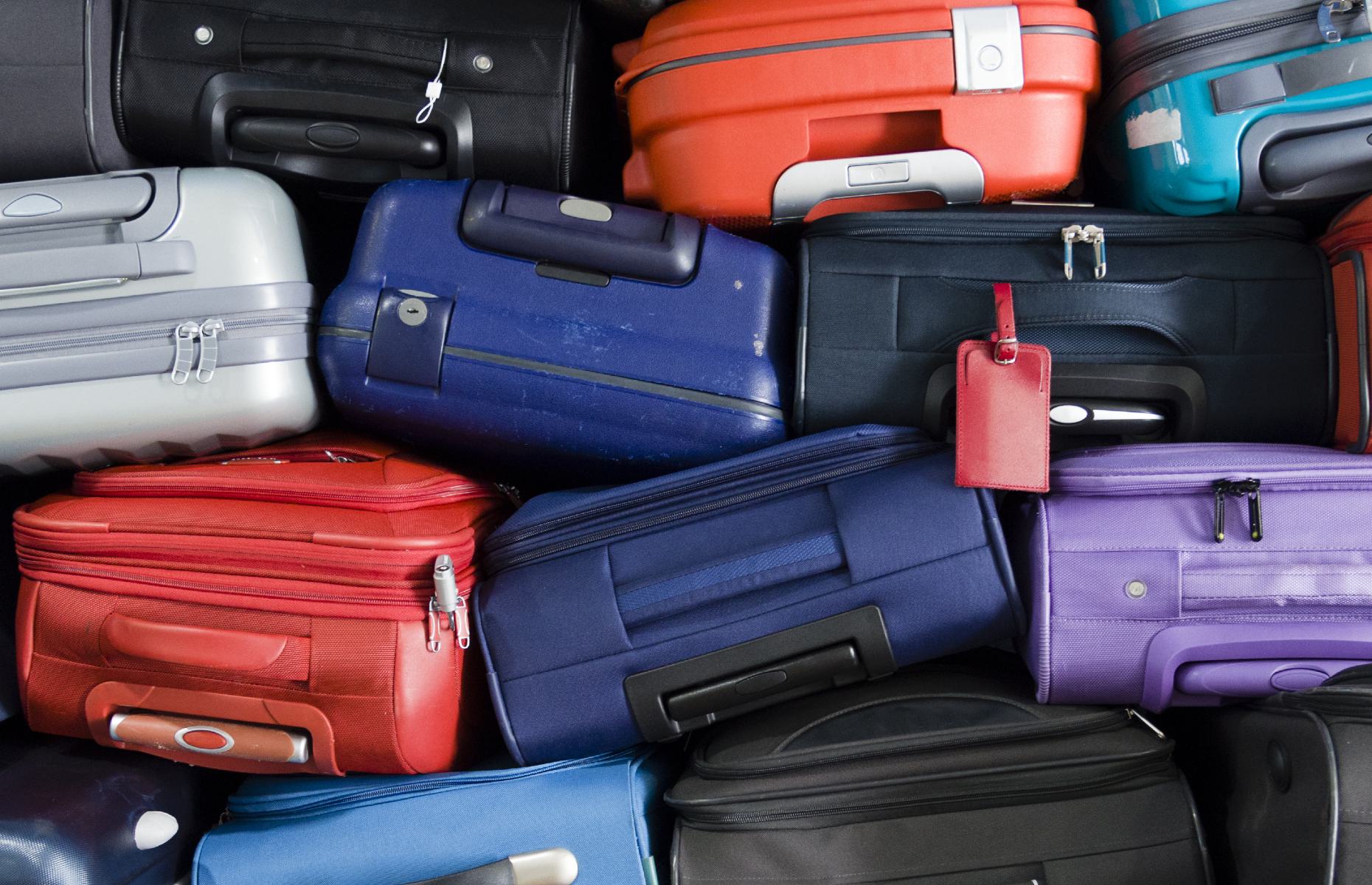 Multi-coloured suitcases stacked on top of each other (Image: Maurizio Milanesio/Shutterstock)
