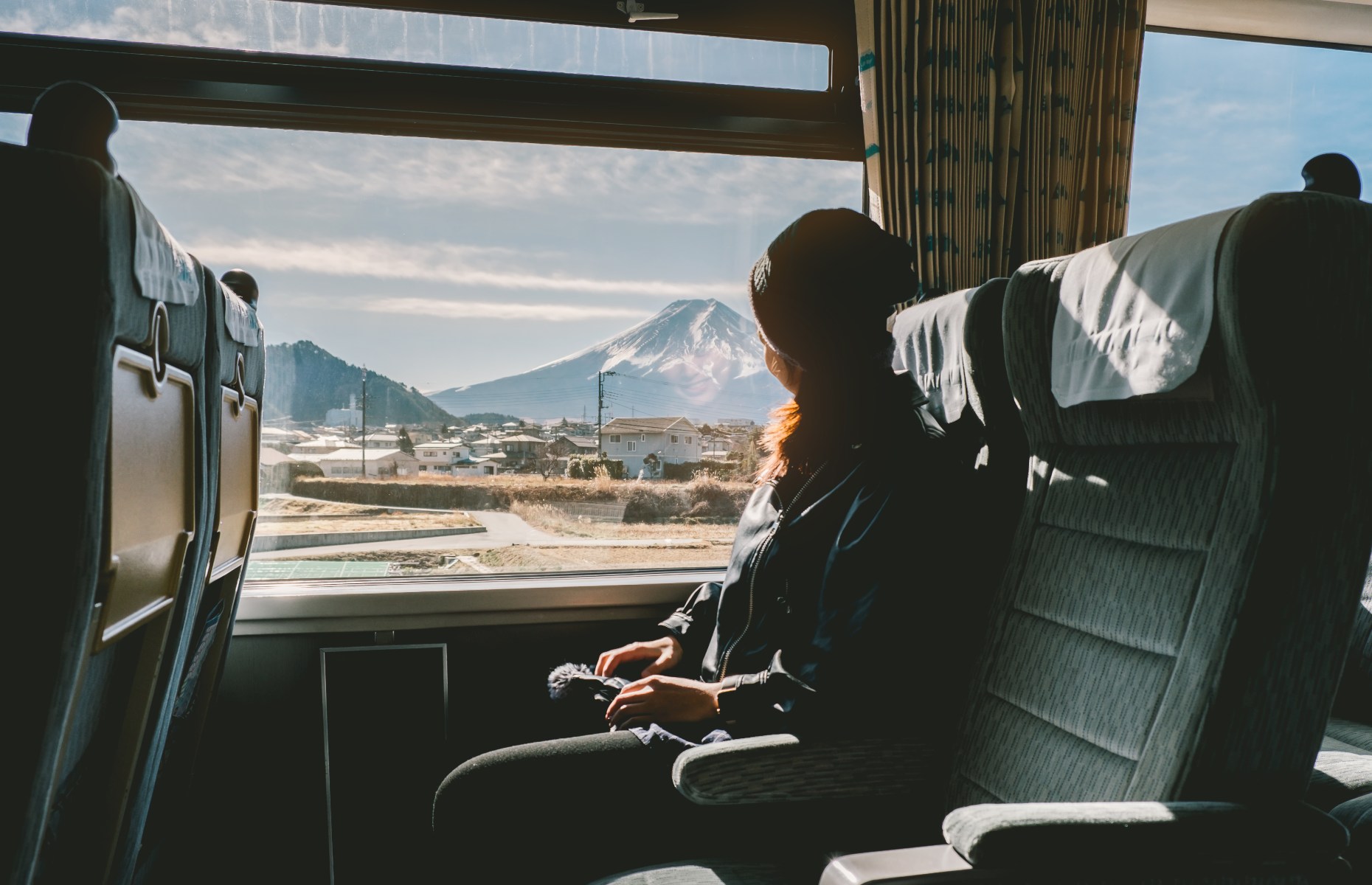 Person gazing out of train window at Mount Fuji (Image: Natee Meepian/Shutterstock)