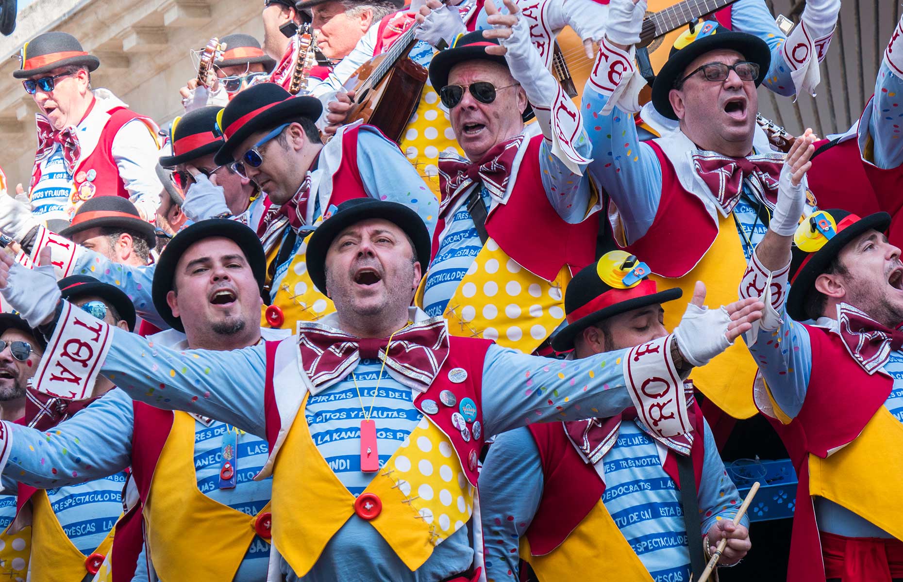 Spanish people in coloured costumes celebrate Carnaval de Cadiz carnival in Spain