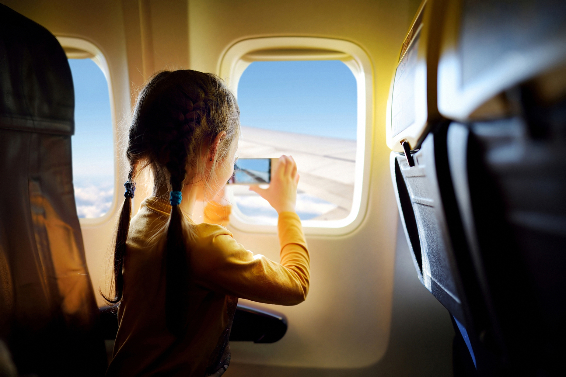 Girl taking pictures on a plane