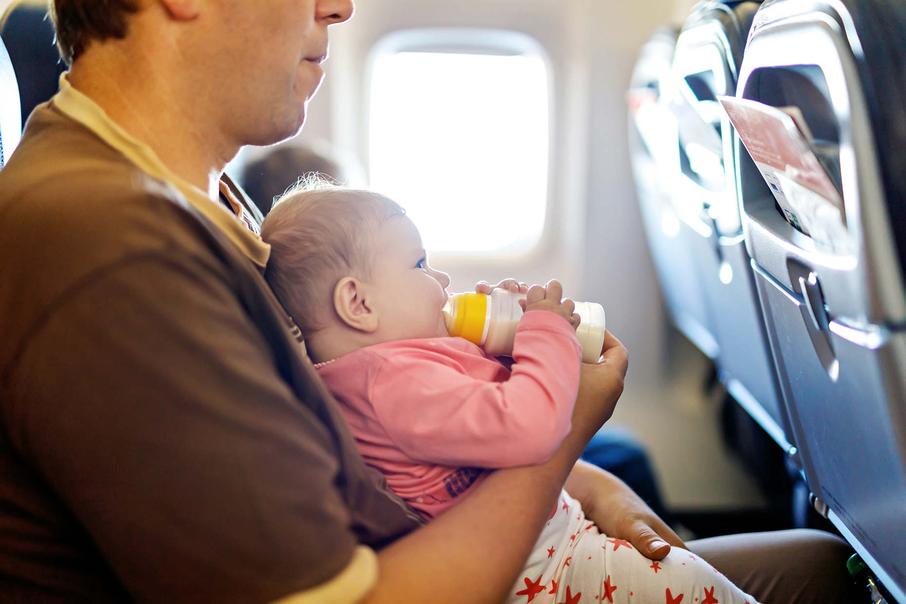 Father holding baby on a plane