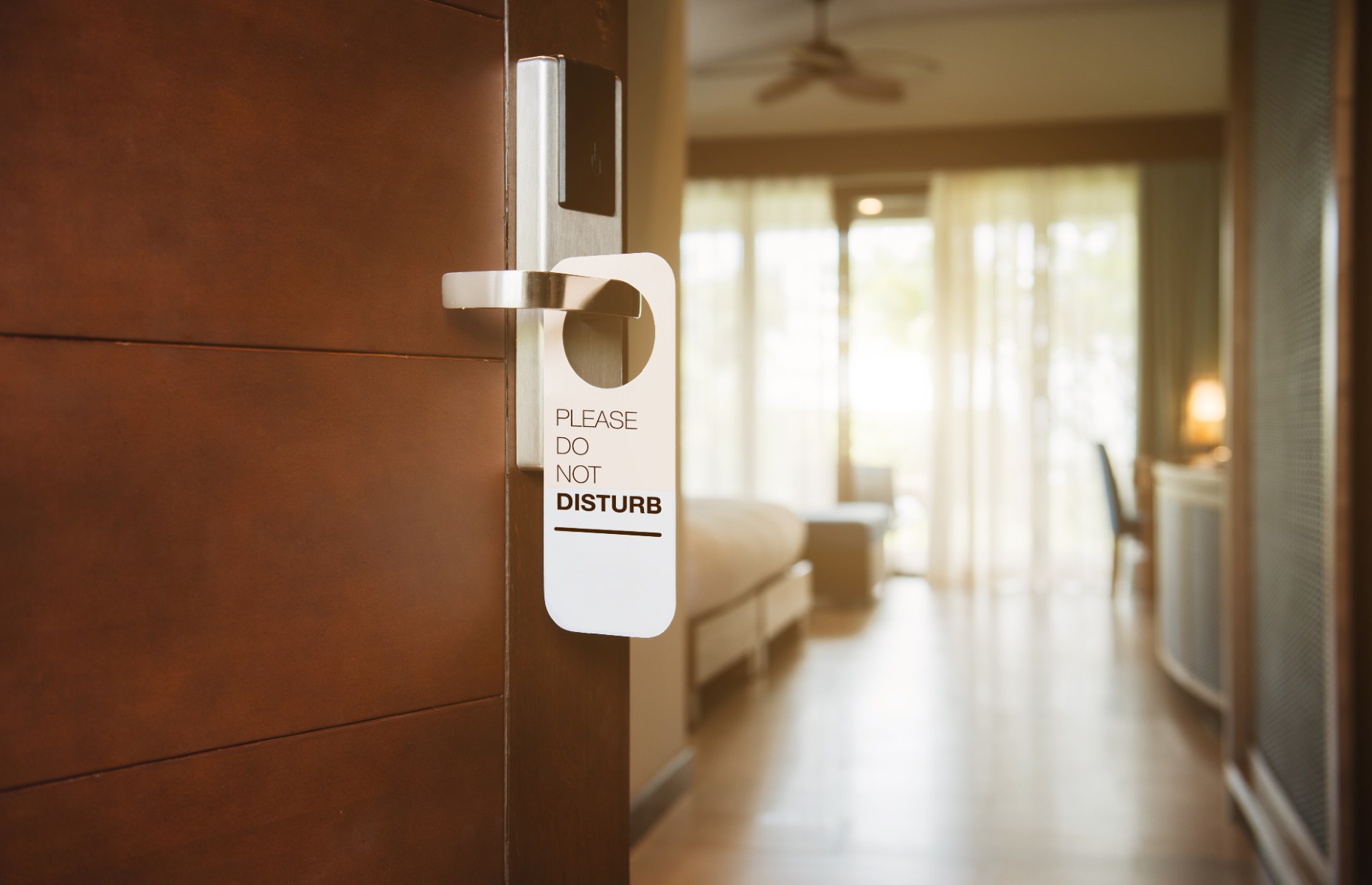 Do not disturb sign on hotel door (Makistock/Shutterstock)