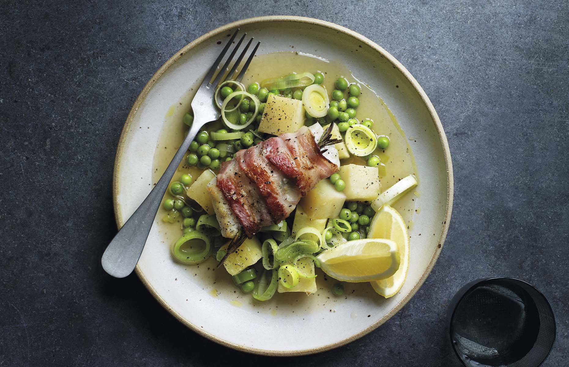 Bacon-wrapped cod with peas, leeks and potatoes (Image: Waitrose & Partners/loveFOOD)