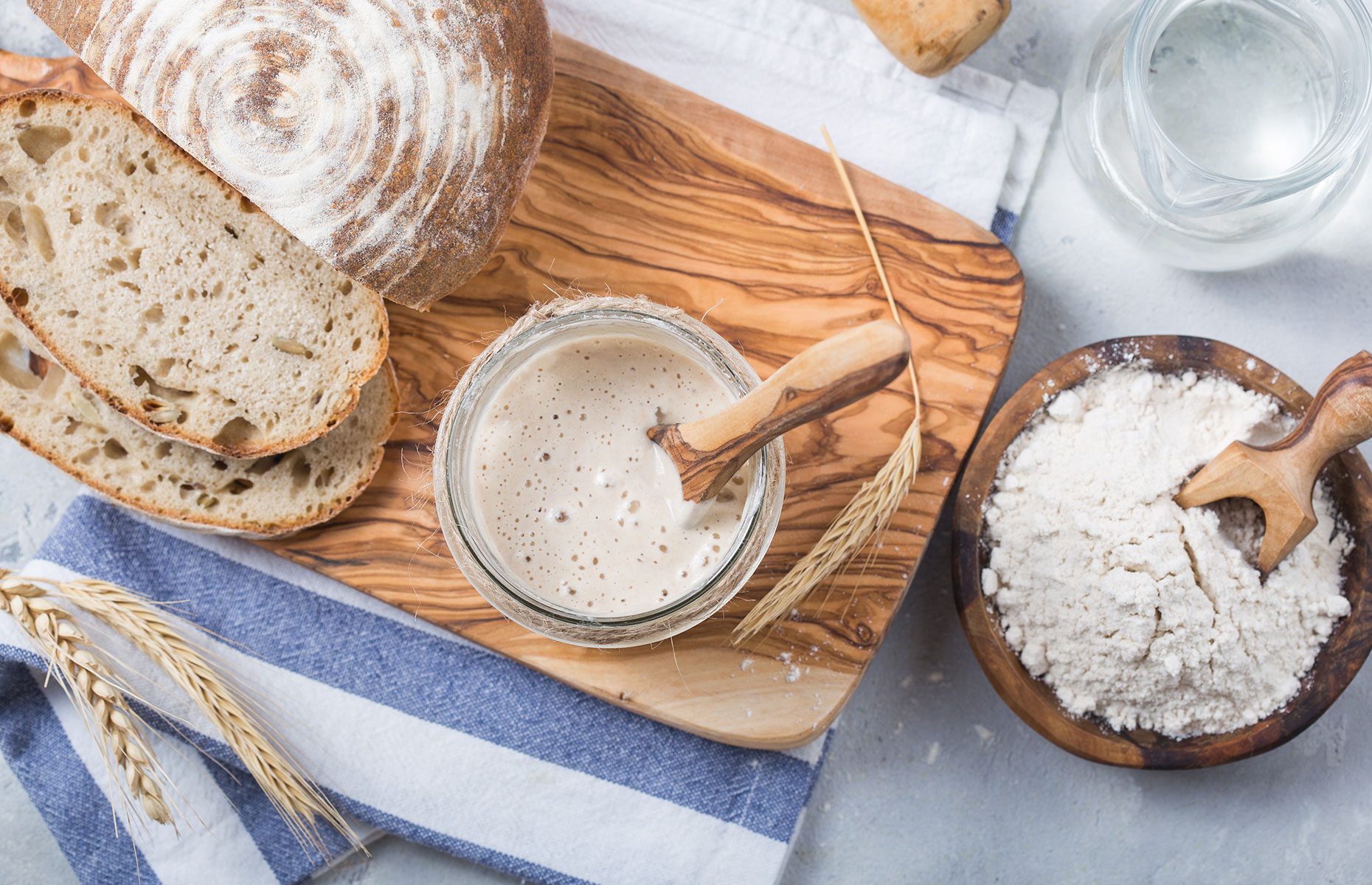Sourdough starter with flour and a loaf (Image: Sokor Space/Shutterstock)