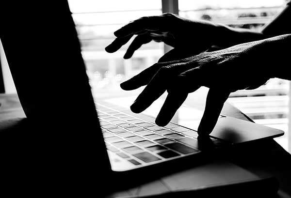 Unknown person using a laptop. (Image: Shutterstock)