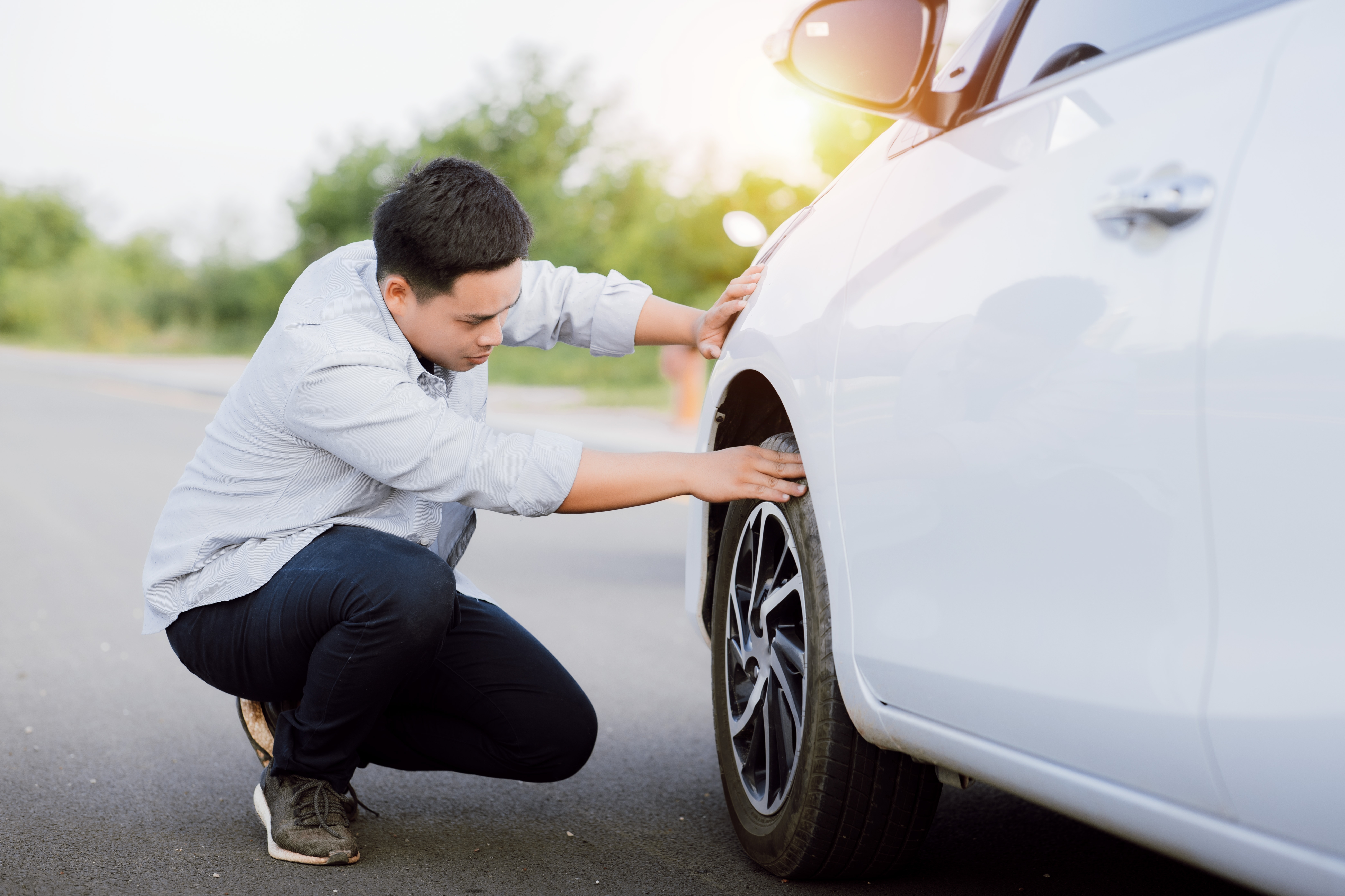 Man checking a tire (Image: Feelimage - Shutterstock)