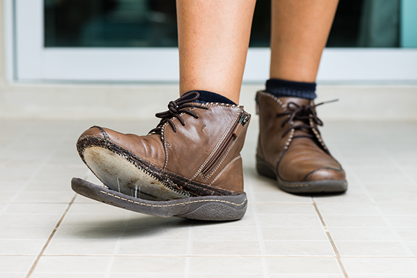 A pair of boots with a broken sole. (Image: Shutterstock)