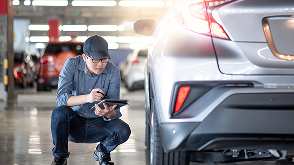 Man inspecting a car. (Image: Shutterstock)