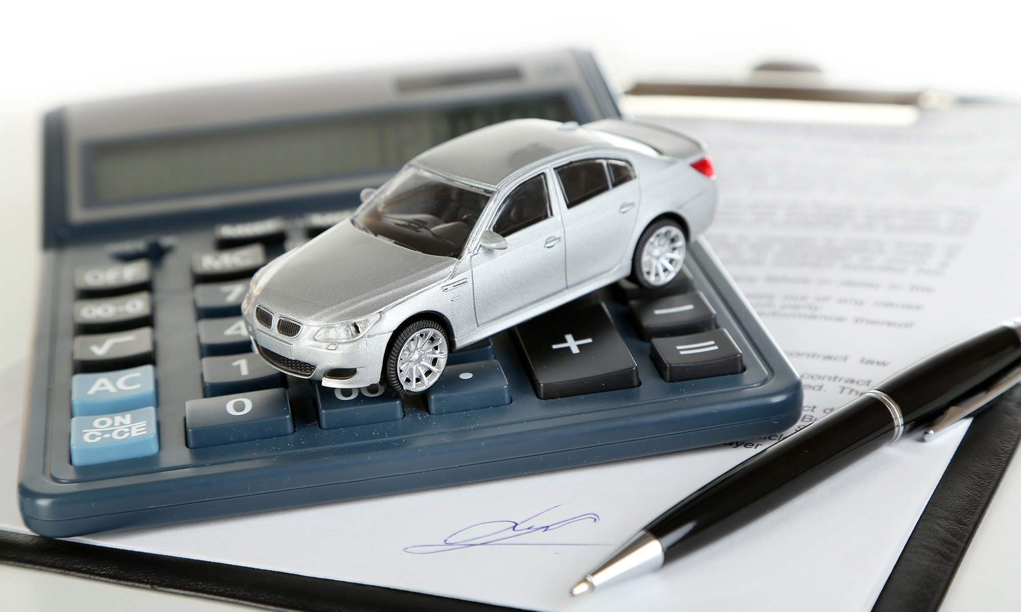 Miniature car on calculator. (Image: Shutterstock)