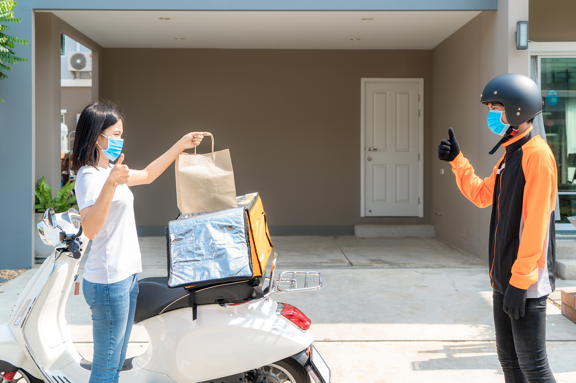 Woman getting takeaway delivered contact-free. (Image: Shutterstock)