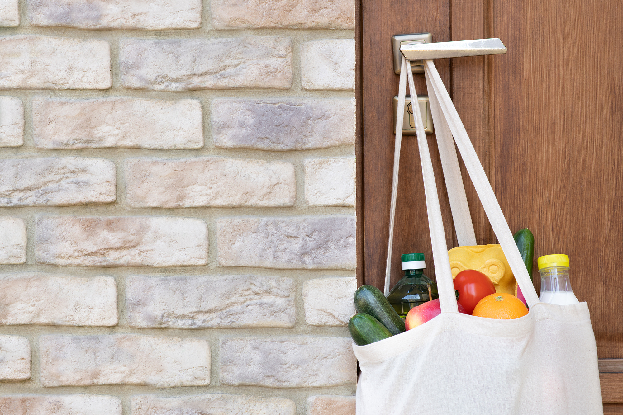 Bag of groceries hanging on doorknob. (Image: Shutterstock)