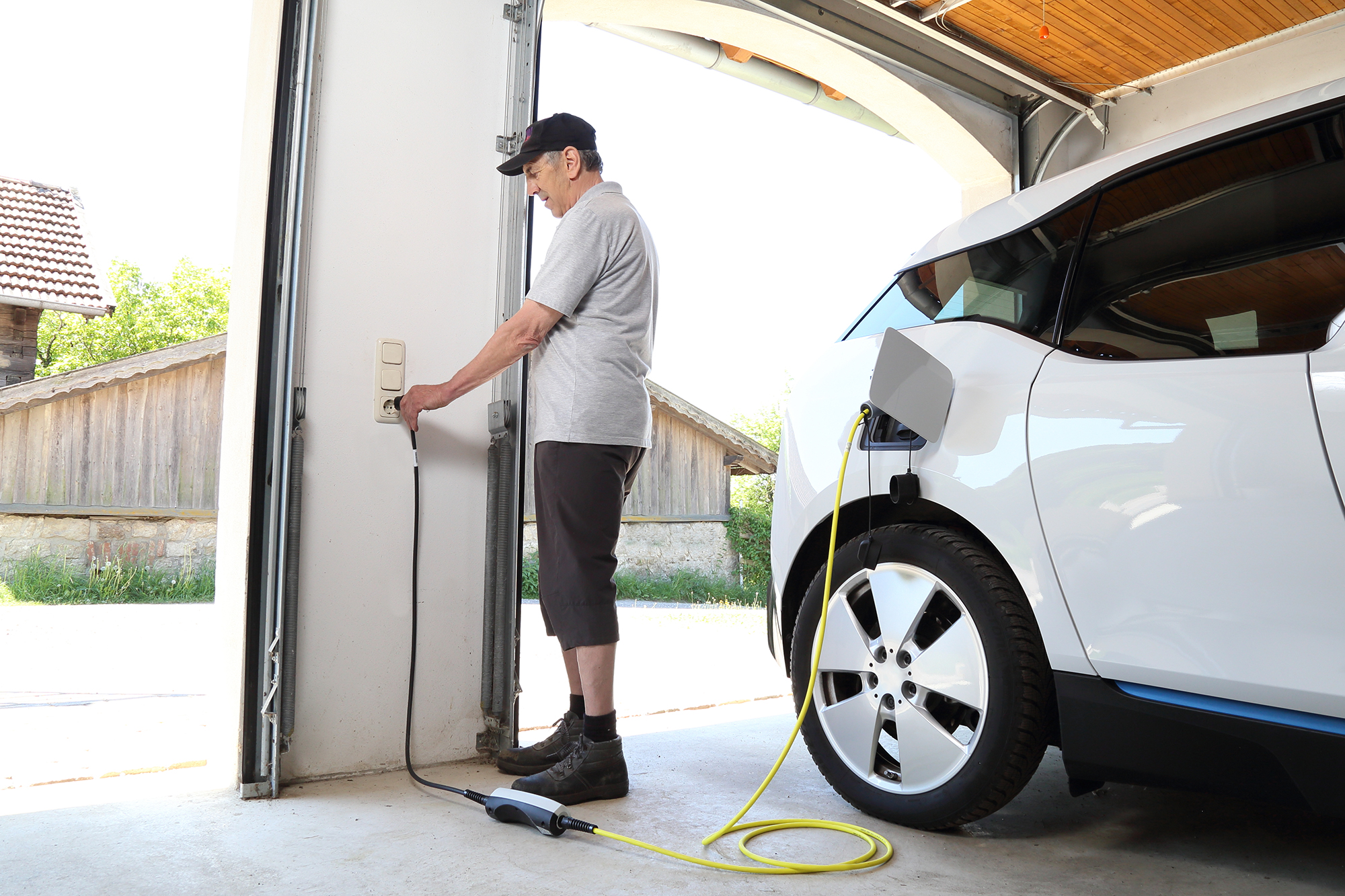 Man charging electric car at home. (Image: Shutterstock)