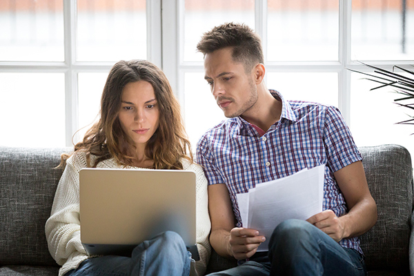 A couple checking an insurance policy. (Image: Shutterstock)