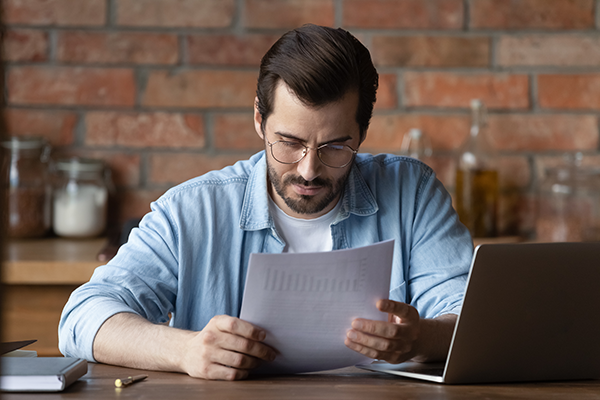 A man looking at documents. (Image: Shutterstock)