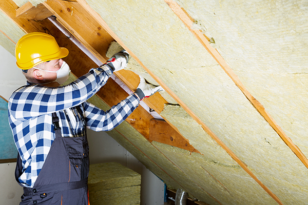 Professional installing loft insulation. (Image: Shutterstock)