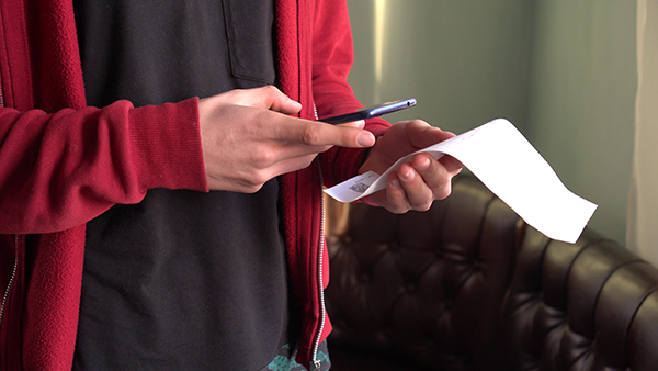 A man holding a receipt. (Image: Shutterstock)