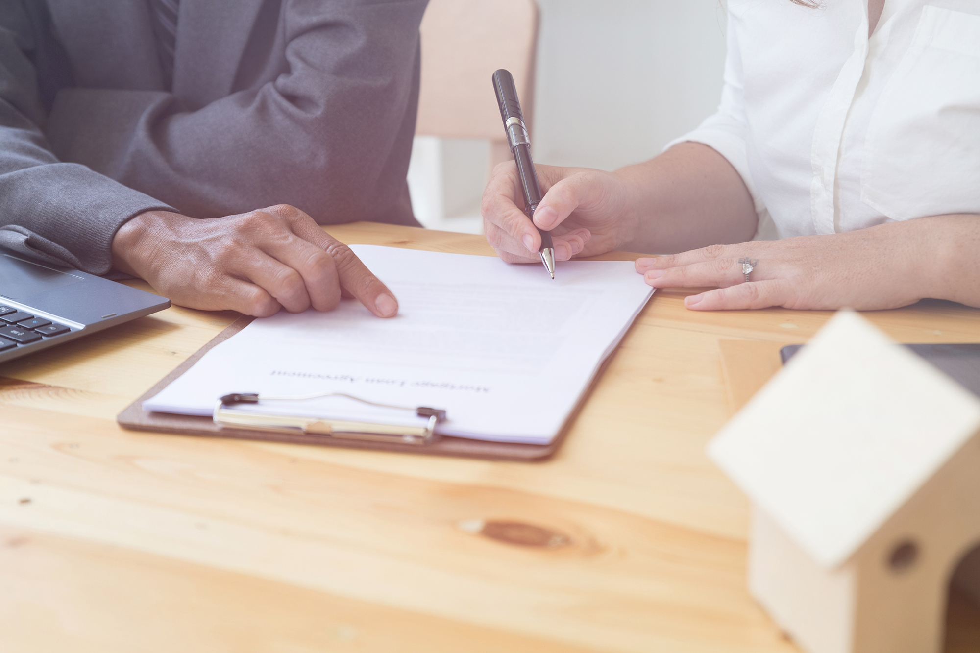 Woman signing mortgage loan agreement. (Image: Shutterstock)