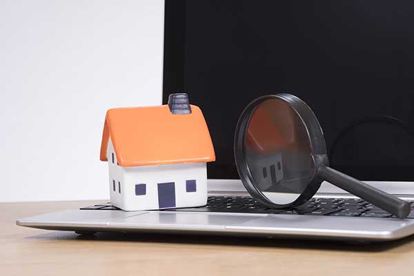 Tiny house model on top of laptop. (Image: Shutterstock)