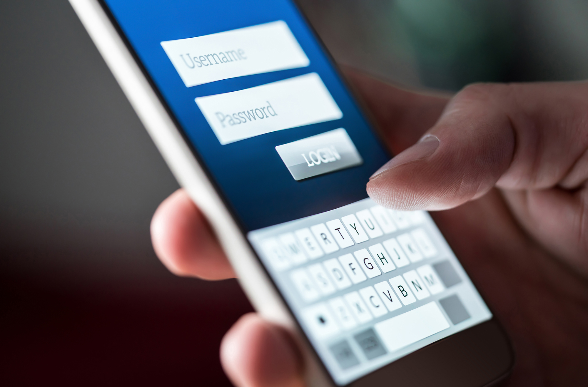 Man using a phone to log into banking app. (Image: Shutterstock)