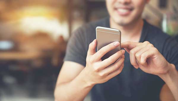 Man using a phone in public. (Image: Shutterstock)