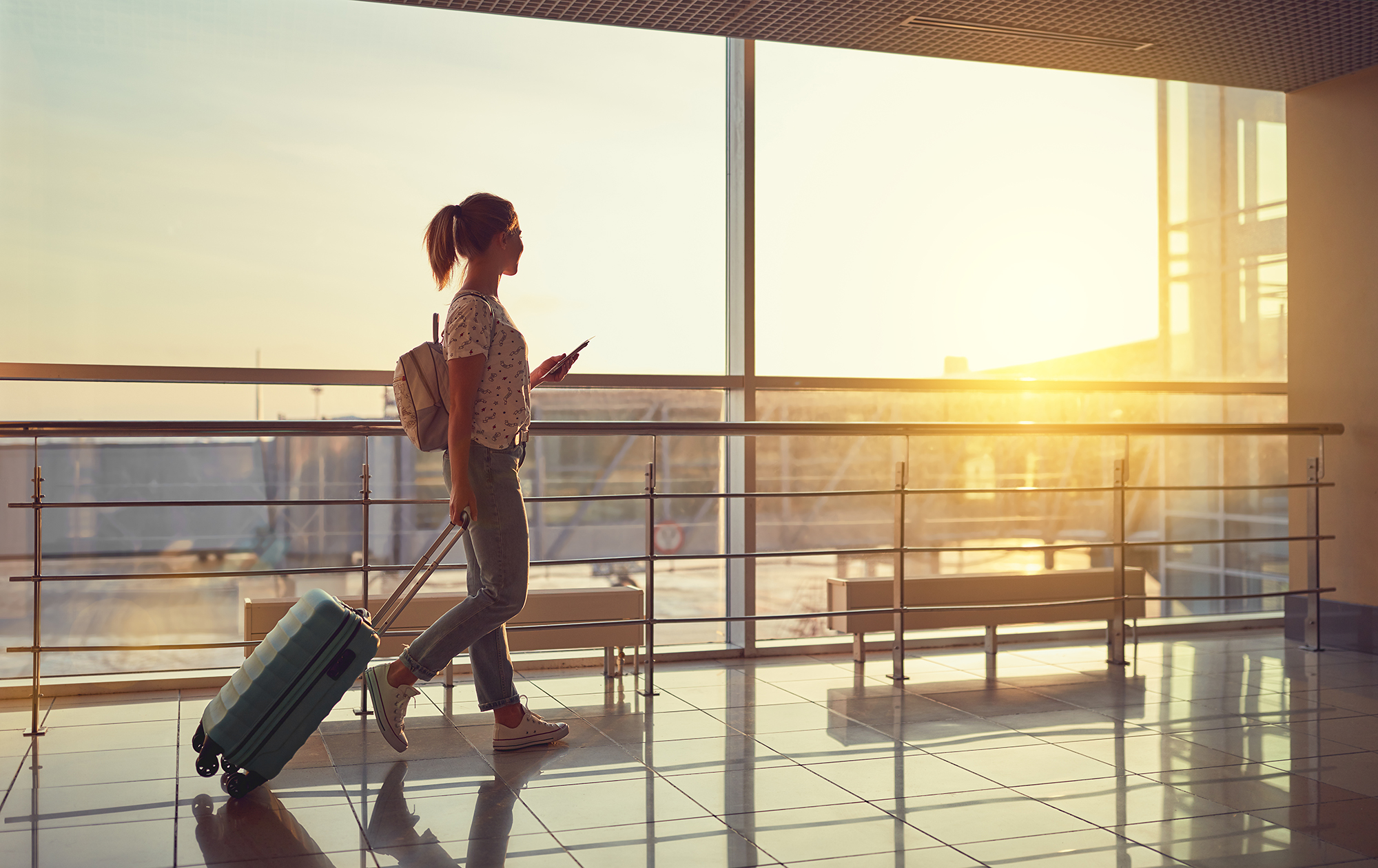 Woman walking through an airport. (Image: Shutterstock)