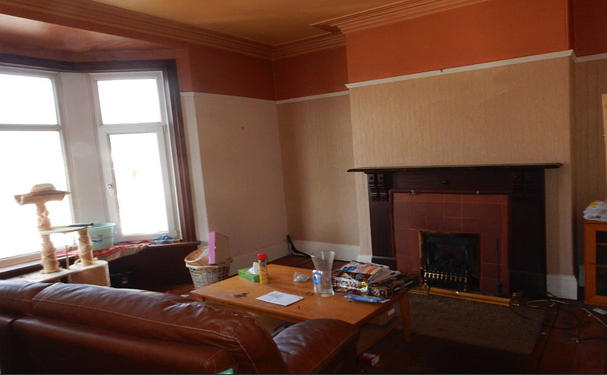 The living room is bathed in light from the expansive bay window. Image: Auction House