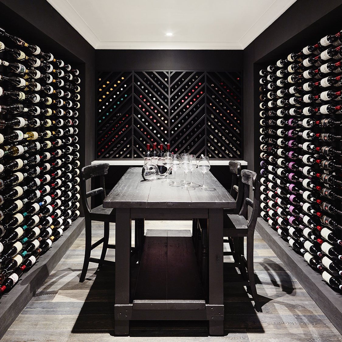 Black wine cellar with built-in wooden cabinets, designed by Greg Natale - Instagram 