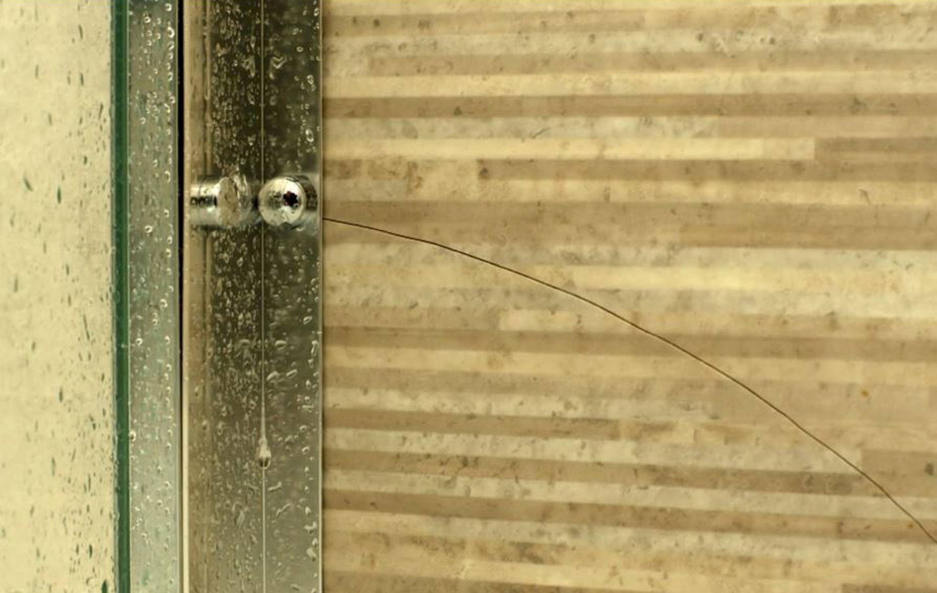 A gaps in the shower tiling lets water leak out onto the wall. Image: BBC