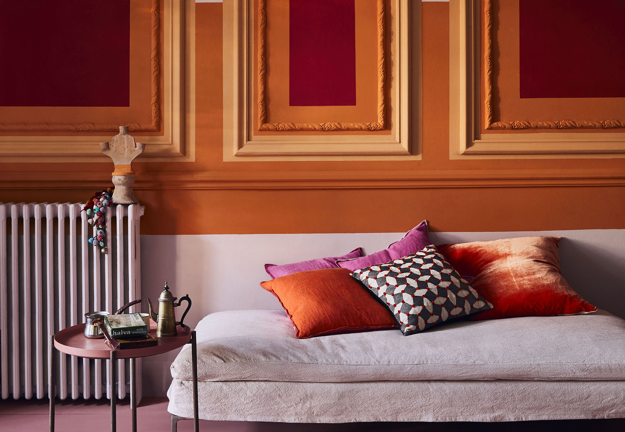 These painted panels add an antique touch to a vibrant living room scheme. Image: Annie Sloan