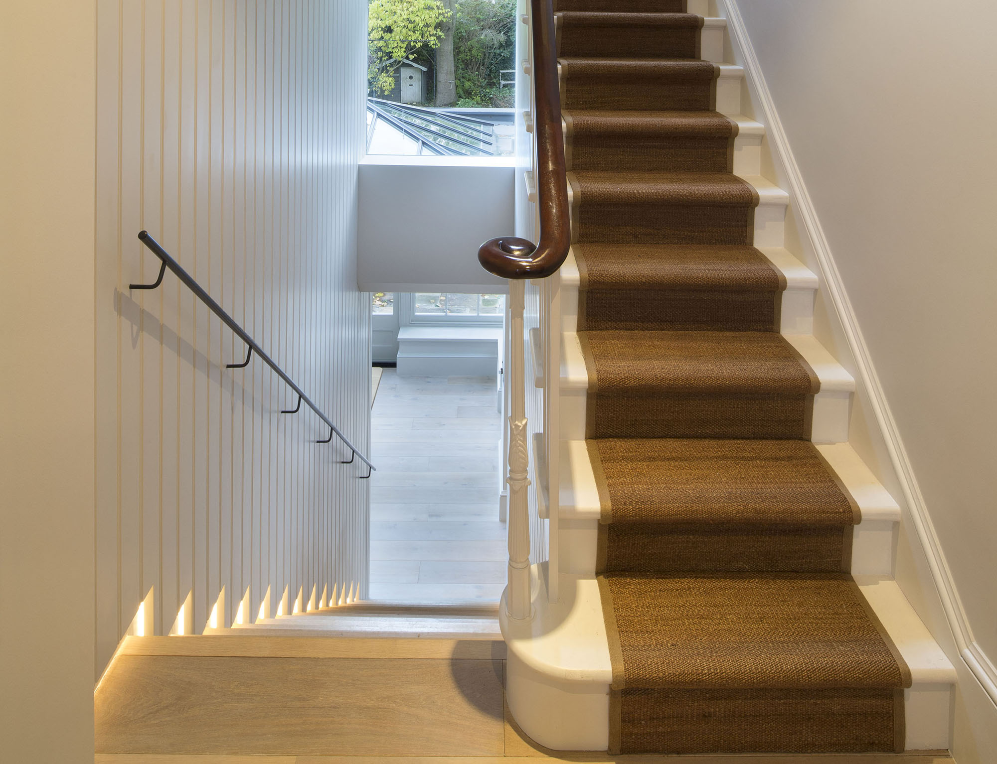 A curved banister and ornate balustrades are the stars of the show in this two-tone hallway. Image: Cousins and Cousins