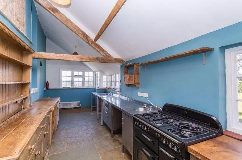 The kitchen features rustic exposed beams and period windows. Image: OnTheMarket