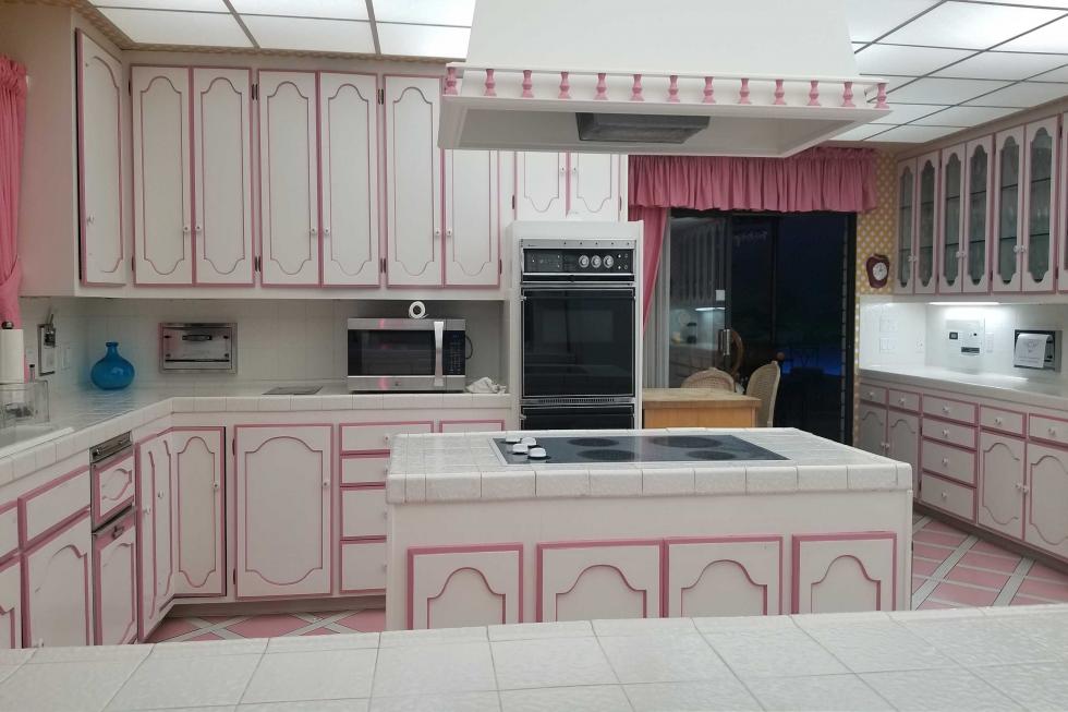 Pink-trimmed cabinets pair with diamond pink floor tiles for the ultimate retro kitchen. Image: Berkshire Hathaway