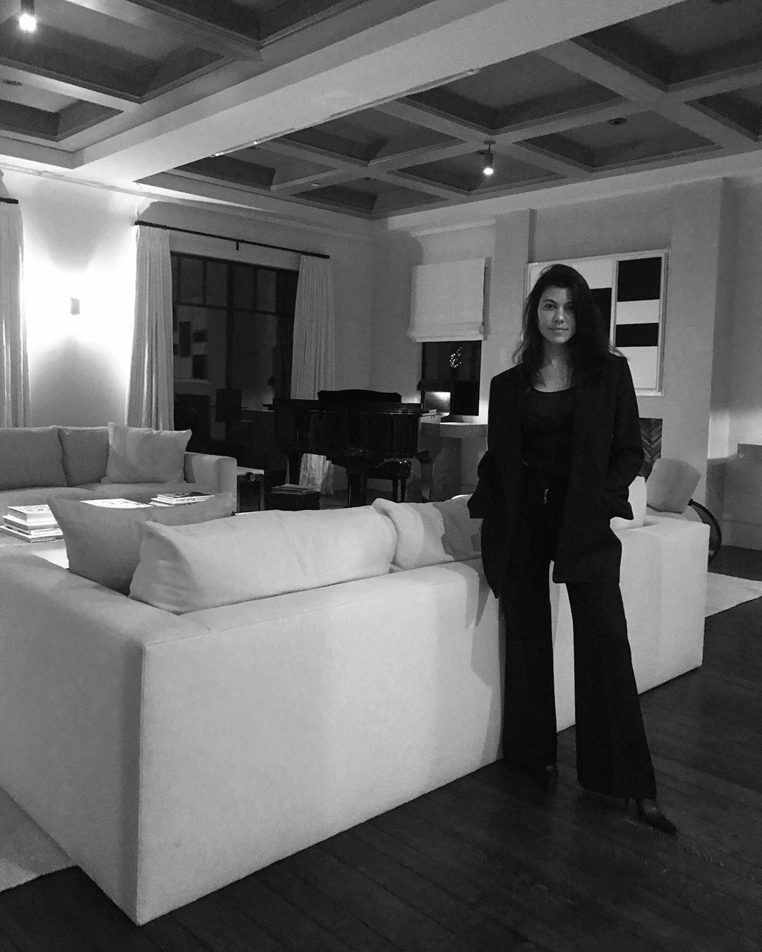 Dark ceiling detailing balances out the living room's clean white furnishings. Image: @kourtneykardash/Instagram